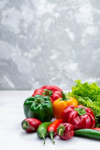 Foto gratuita ensalada verde fresca junto con pimientos de colores y pimientos picantes en la mesa de luz