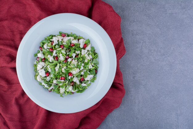 Ensalada verde con hierbas, coliflor y semillas de granada