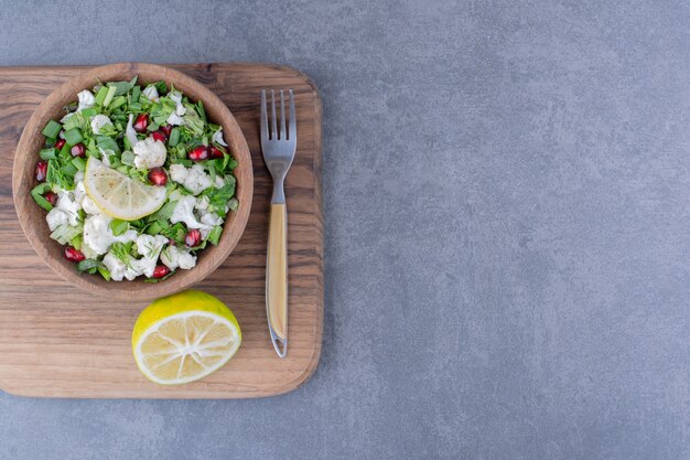 Ensalada verde con hierbas, coliflor y semillas de granada