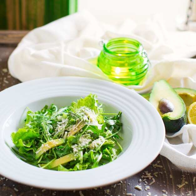 Ensalada verde con lechuga, aguacate, rúcula y queso parmesano