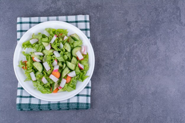 Ensalada verde en un plato con ingredientes mixtos.