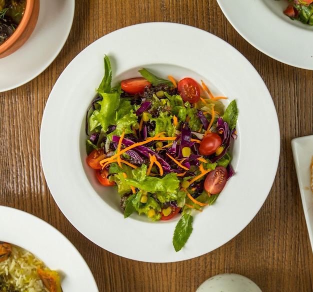 Ensalada verde de verano fresco con hierbas y tomates.