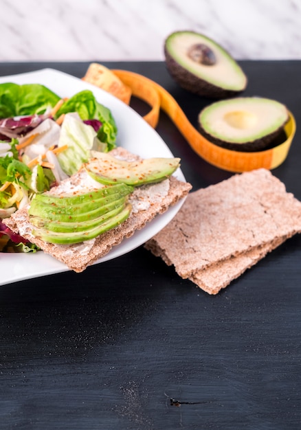 Ensalada de verduras con aguacate en pan crujiente en mesa