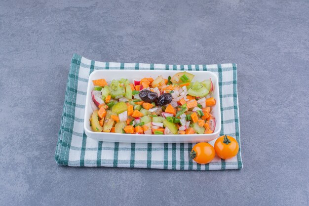 Ensalada de verduras con alimentos de temporada en un plato de cerámica