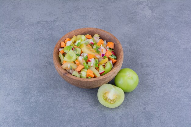 Ensalada de verduras con alimentos de temporada en un plato de madera