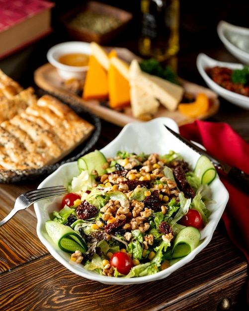 Ensalada de verduras con ciruelas pasas, nueces y maíz