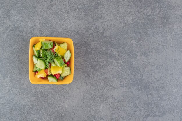 Ensalada de verduras deliciosa en un tazón de naranja. Foto de alta calidad