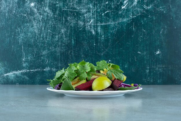 Ensalada de verduras frescas en un plato blanco.