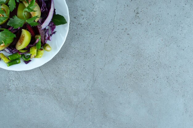 Ensalada de verduras frescas en un plato blanco.