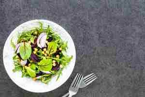 Foto gratuita ensalada de verduras frescas con remolacha, rúcula, cebolla roja y acedera en una placa blanca.