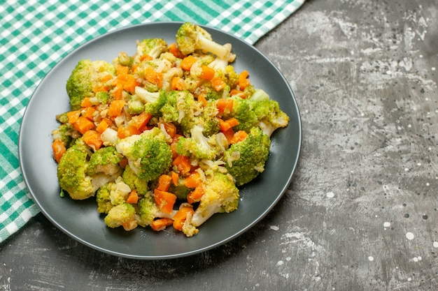 Ensalada de verduras frescas y saludables en una toalla verde despojado de mesa gris