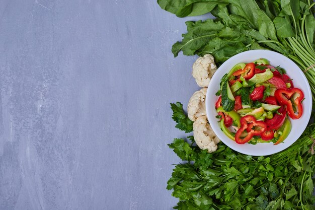 Ensalada de verduras con hierbas en azul