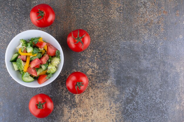 Ensalada de verduras con hierbas y tomates rojos en un plato