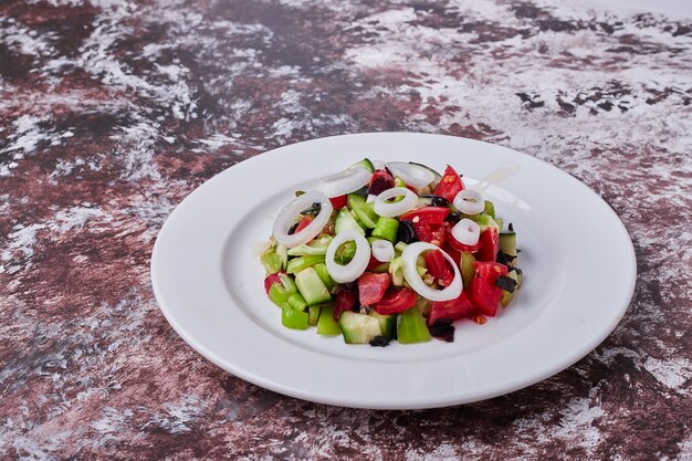 Ensalada de verduras con ingredientes picados y picados mezclados con aceite