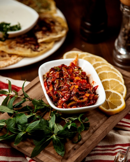 Foto gratuita ensalada de verduras con ketchup y rodajas de limón