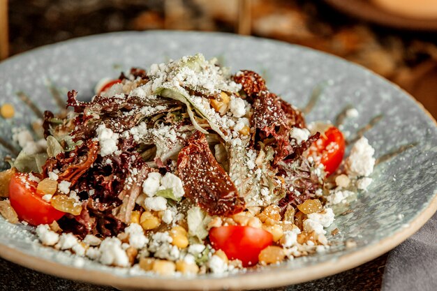 Ensalada de verduras con lechuga tomates secos queso de cabra pasas tomate cherry