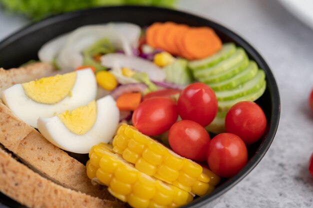 Ensalada de verduras con pan y huevos en la sartén.