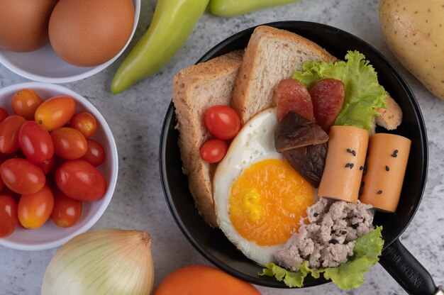 Ensalada de verduras con pan y huevos en la sartén.