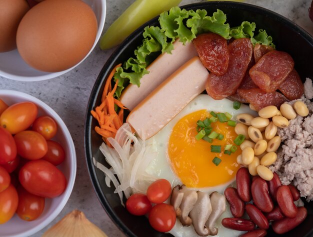 Ensalada de verduras con pan y huevos en la sartén.