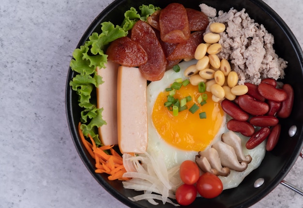 Ensalada de verduras con pan y huevos en la sartén.