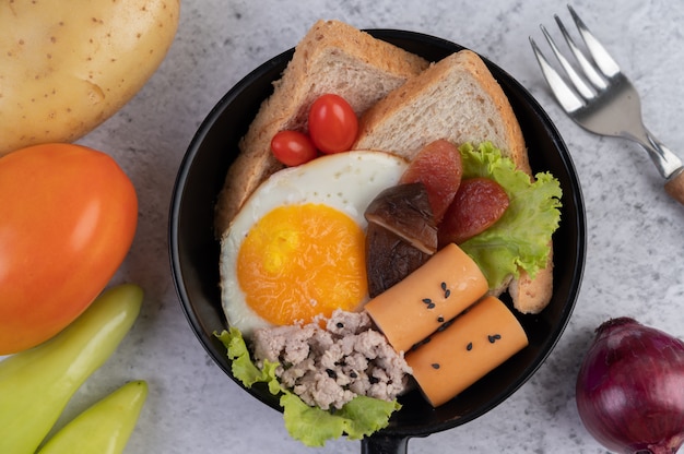 Foto gratuita ensalada de verduras con pan y huevos en la sartén.