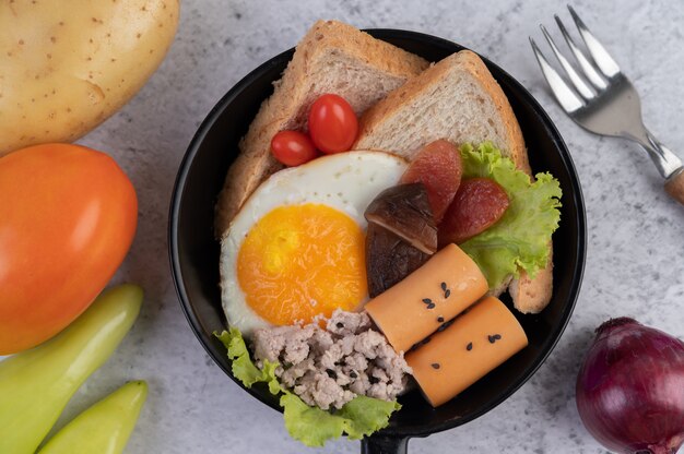 Ensalada de verduras con pan y huevos en la sartén.