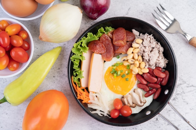 Ensalada de verduras con pan y huevos en la sartén.