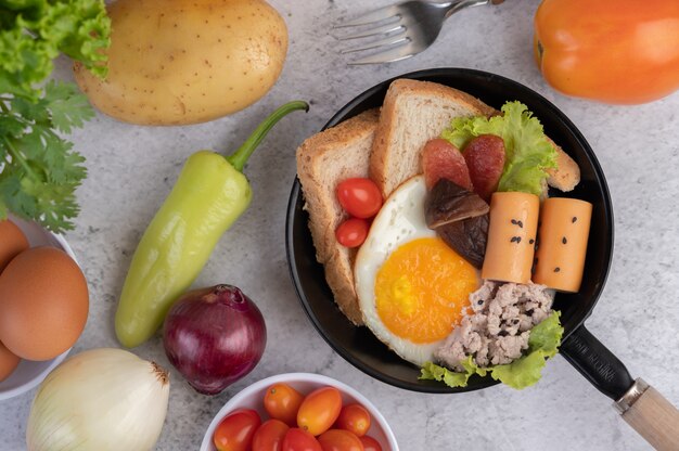 Ensalada de verduras con pan y huevos en la sartén.