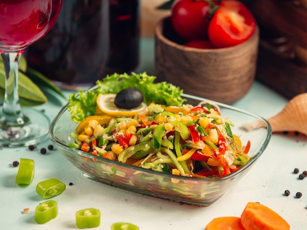 Ensalada de verduras con pimientos, pepino, maíz y sésamo