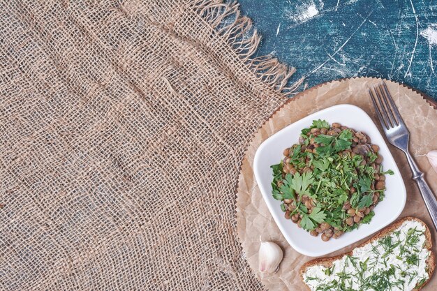 Ensalada de verduras en un plato blanco con tostadas.