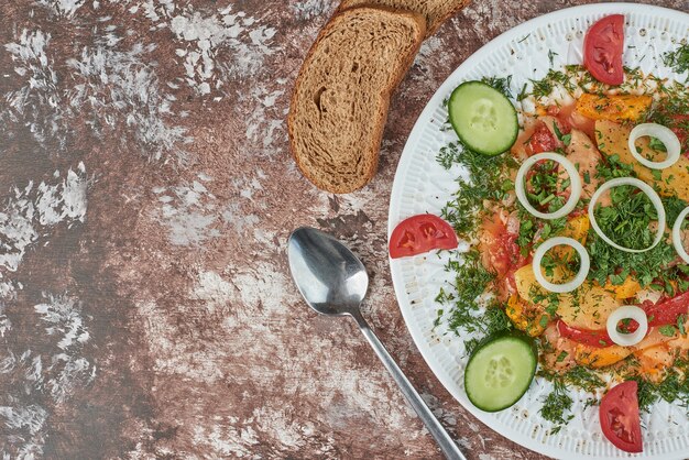 Ensalada de verduras en un plato de cerámica blanca con alimentos coloridos