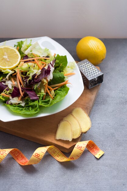 Ensalada de verduras en un plato con cinta métrica