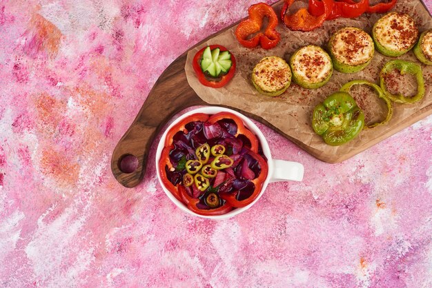 Ensalada de verduras en un plato de madera.