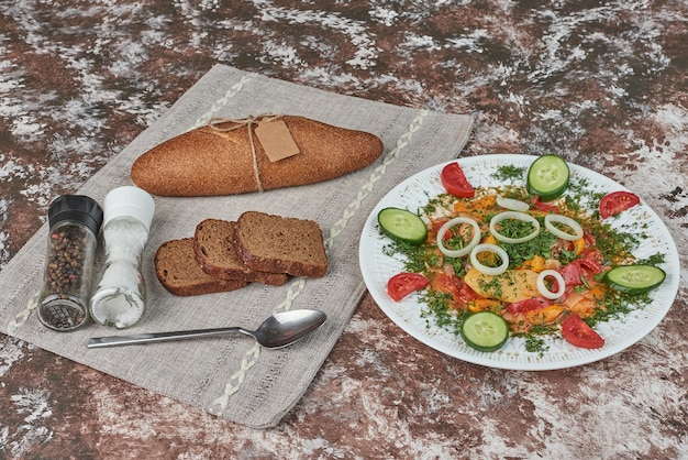 Ensalada de verduras con rebanadas de pan.