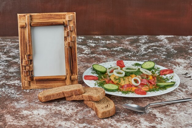 Ensalada de verduras con rebanadas de pan.