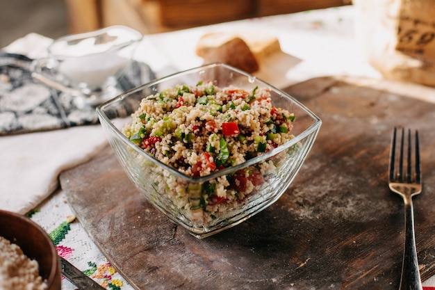 Ensalada de verduras en rodajas Vitamina de colores poco enriquecida junto con arroz salado con pimienta sabroso sobre escritorio de madera marrón