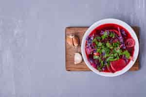 Foto gratuita ensalada de verduras en salsa roja sobre azul