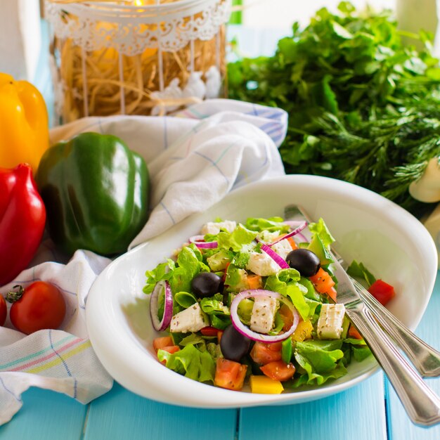 Ensalada de verduras con tomate, lechuga, cebolla morada, pimiento, aceitunas y queso