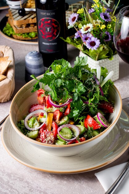 Ensalada de verduras con tomate, pepino, pimiento, cebolla roja, parmesano rallado y perejil