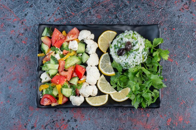 Ensalada de verduras con tomate picado, pepino y hierbas.