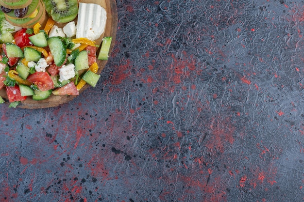 Ensalada de verduras con tomate picado, pepino y hierbas.