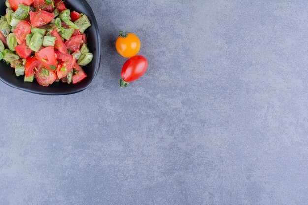 Ensalada de verduras con tomates y judías verdes dentro de un plato