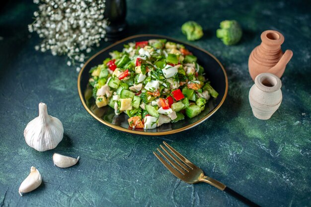 Ensalada de verduras vista frontal se compone de queso de pepino y tomates sobre fondo azul oscuro