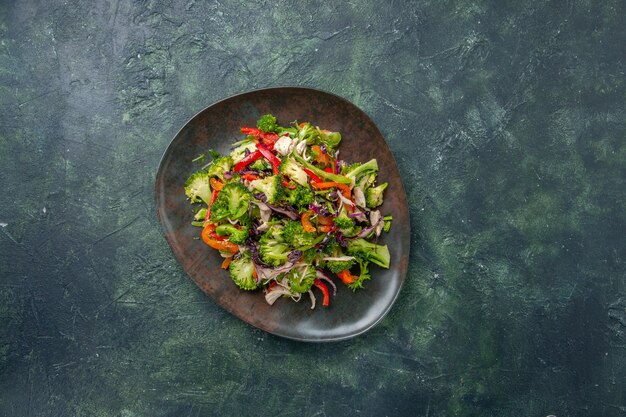 Ensalada de verduras vista superior consta de pimientos, repollo y brócoli sobre fondo oscuro alimentos vacaciones comida fresca dieta saludable madura
