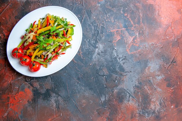 Ensalada de verduras vista superior en placa ovalada en lugar de copia de mesa oscura
