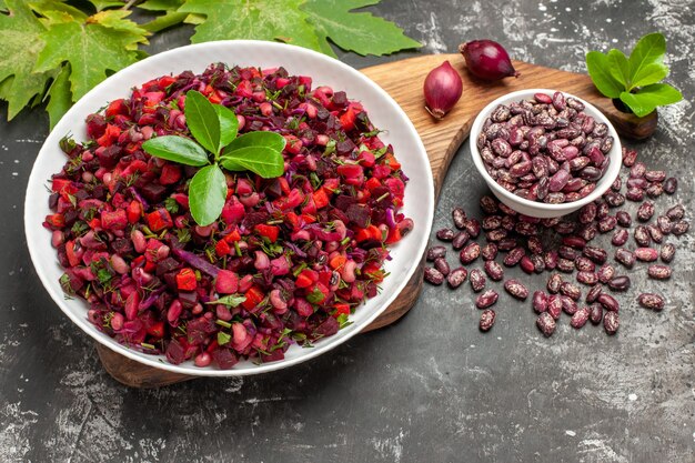 Ensalada de vinagreta de vista superior con remolacha y frijoles en la superficie gris