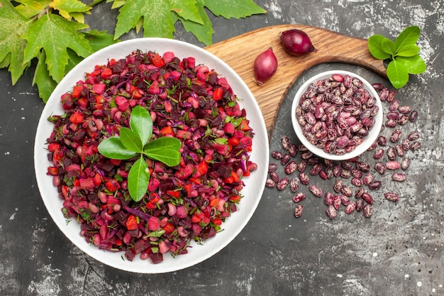 Ensalada de vinagreta de vista superior con remolacha y frijoles en la superficie gris