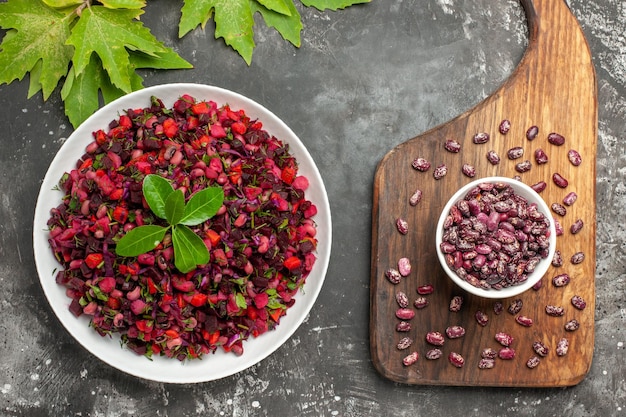 Ensalada de vinagreta de vista superior con remolacha y frijoles en la superficie gris