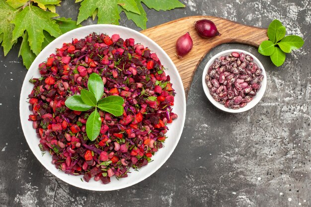 Ensalada de vinagreta de vista superior con remolacha y frijoles en la superficie gris