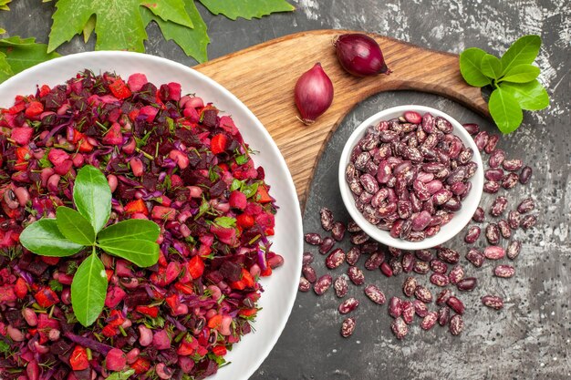 Ensalada de vinagreta de vista superior con remolacha y frijoles en la superficie gris